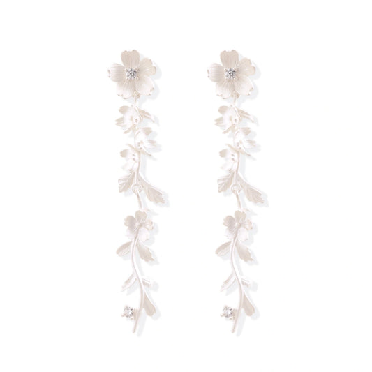 Long sterling silver drop earrings with delicate floral vine design and crystal accents on white background