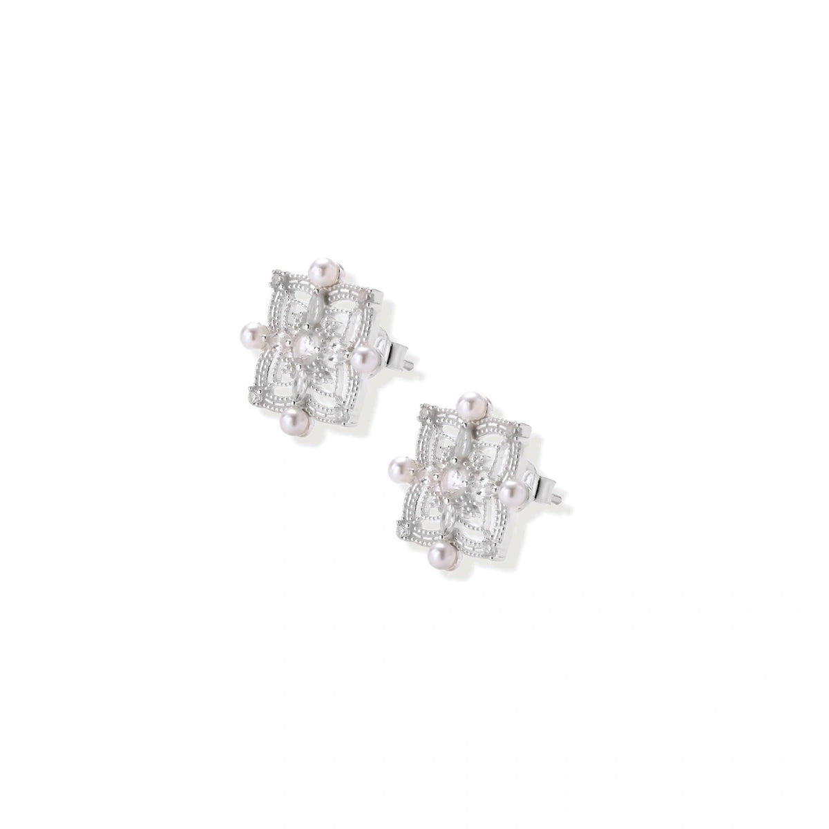 Ornate sterling silver stud earrings with mandala-inspired filigree pattern and four freshwater pearls on beige background