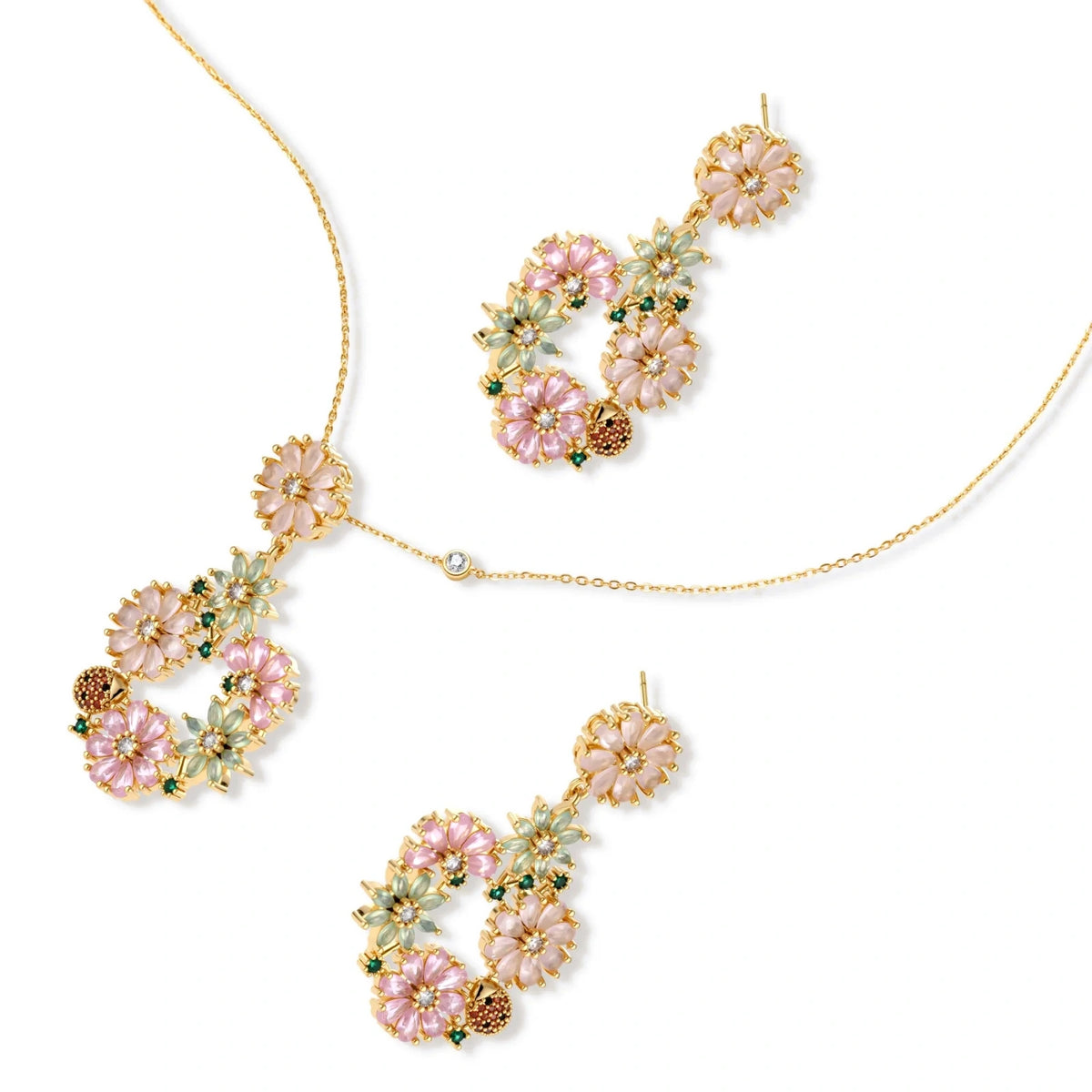 14K gold plated jewelry set with pink and green cubic zirconia flowers arranged in wreath design on cream background