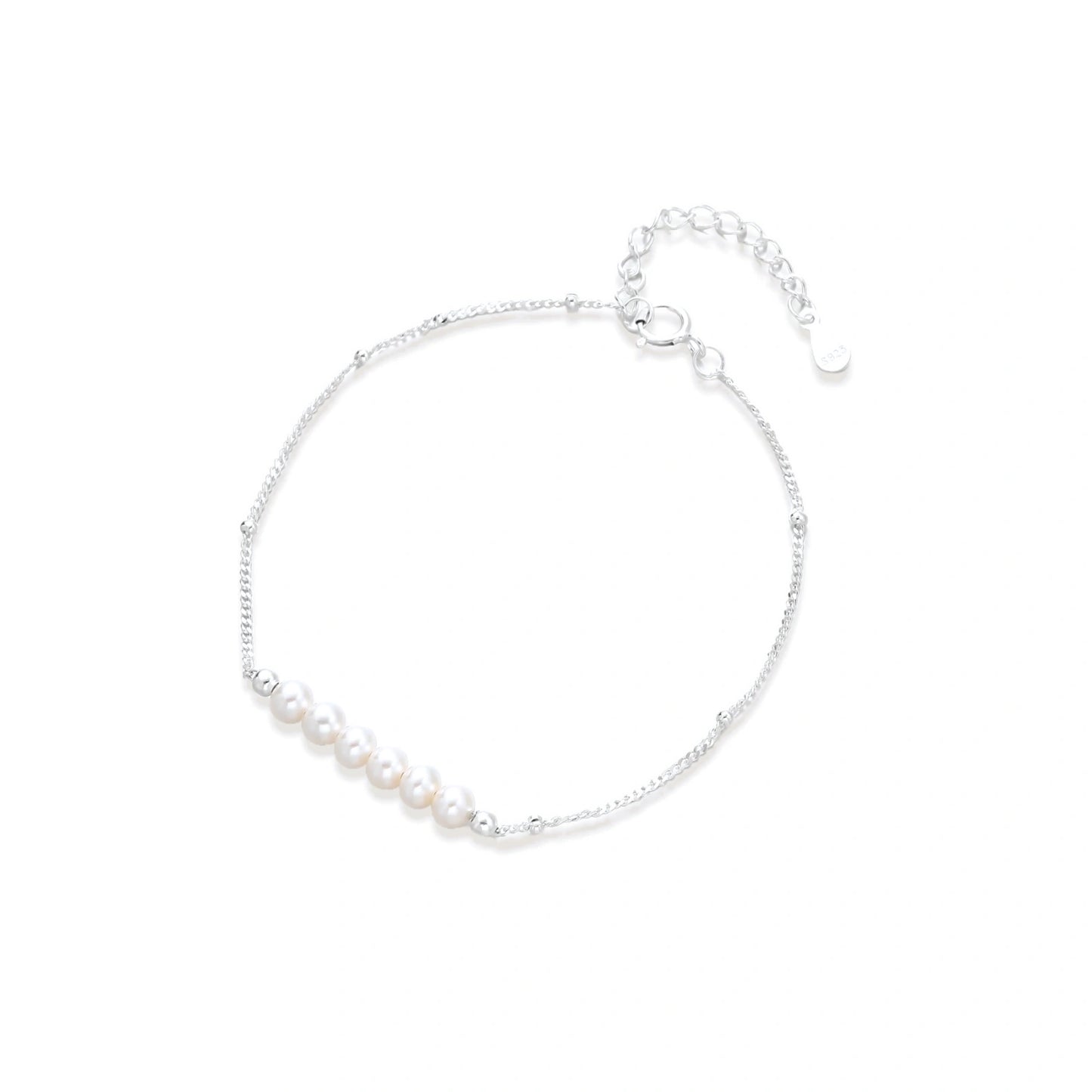 Delicate rhodium-plated silver chain bracelet with row of small baroque pearls centered on white background.