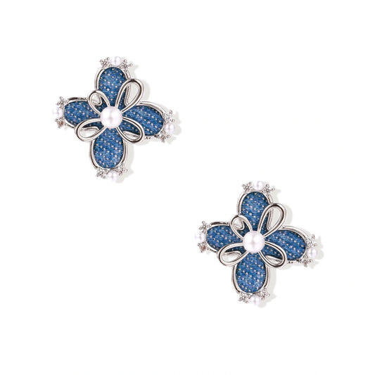 Blue denim fabric flower studs with white gold plated petals, pearl center, and zirconia accents on white background